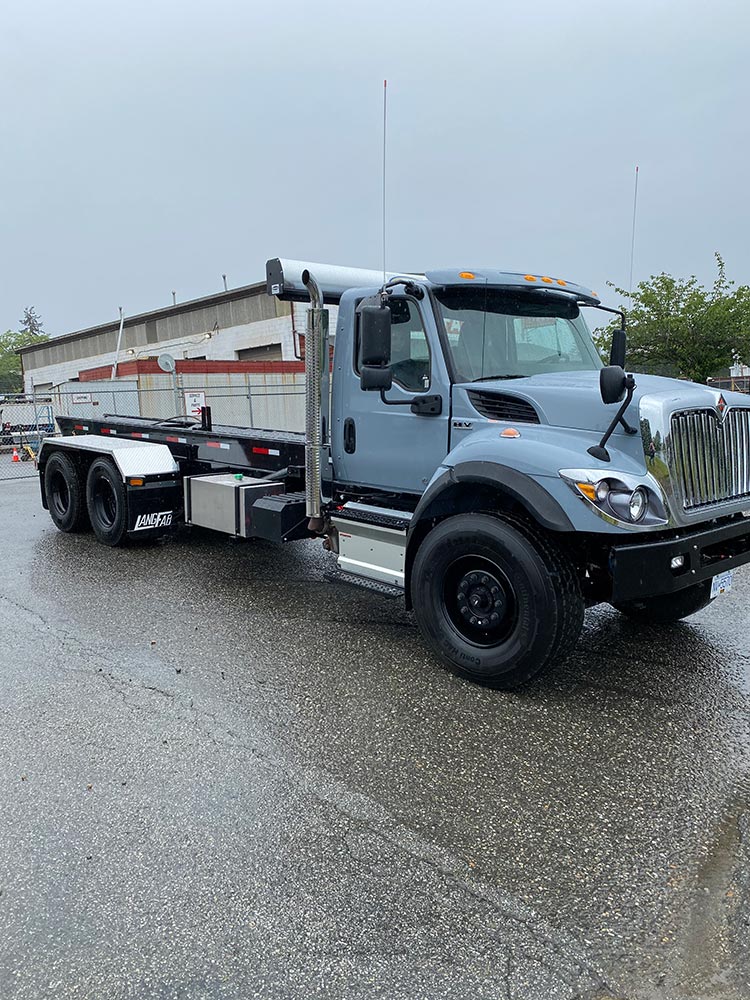 Tandem axle roll off truck